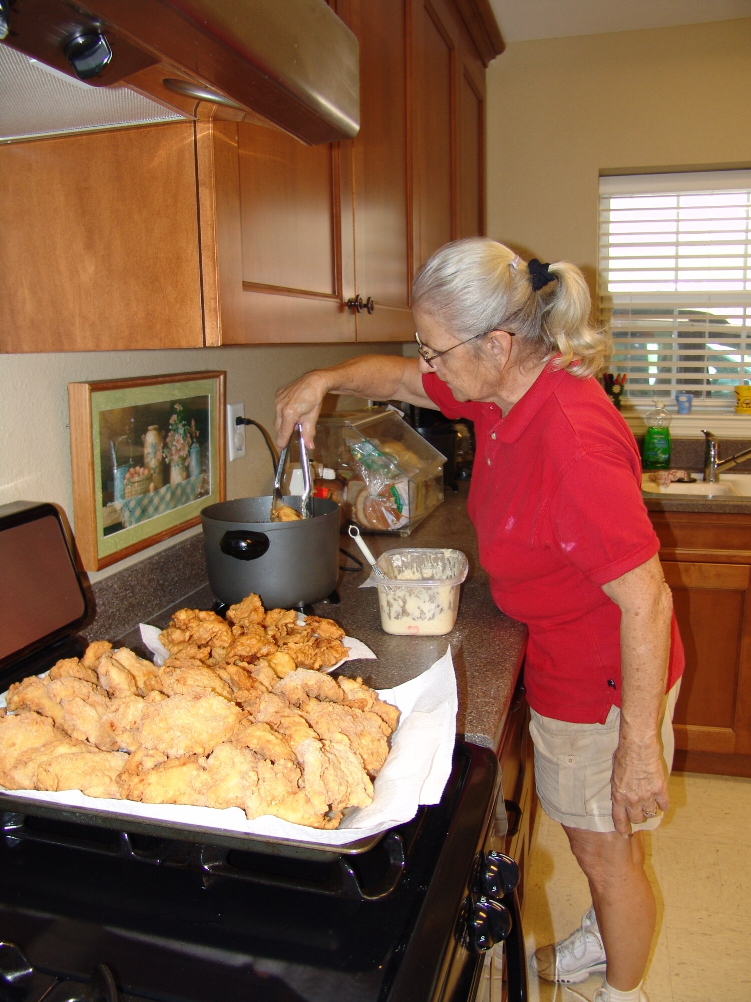 Patricia Looze, main chef at Children in Crisis, prepares fried chicken as part of the evening meal for the residents of the facility. Key workers for the 2009 Combined Federal Campaign visited local charities who are seeking donations during the campaign. (U.S. Air Force photo by Leslie Brown)