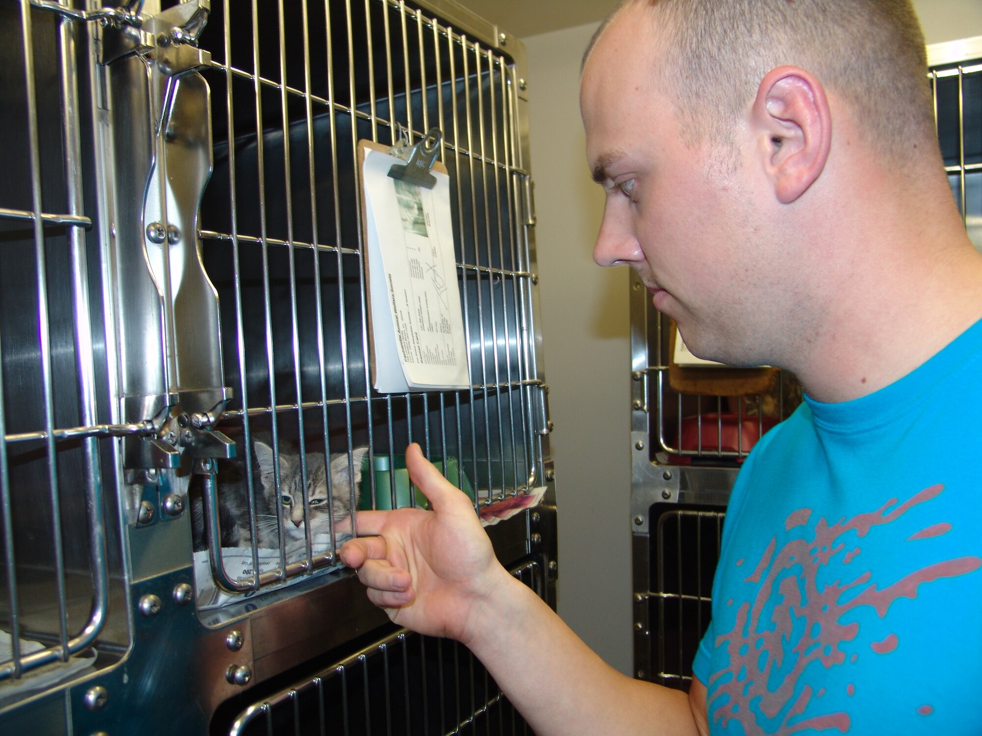 Airman 1st Class Alex Breeland, 96th Communications Group, pets a kitten during a tour of the Panhandle Animal Welfare Society.  Key workers for the 2009 Combined Federal Campaign at Eglin toured local charities seeking assistance during the campaign. (U.S. Air Force photo by Leslie Brown)