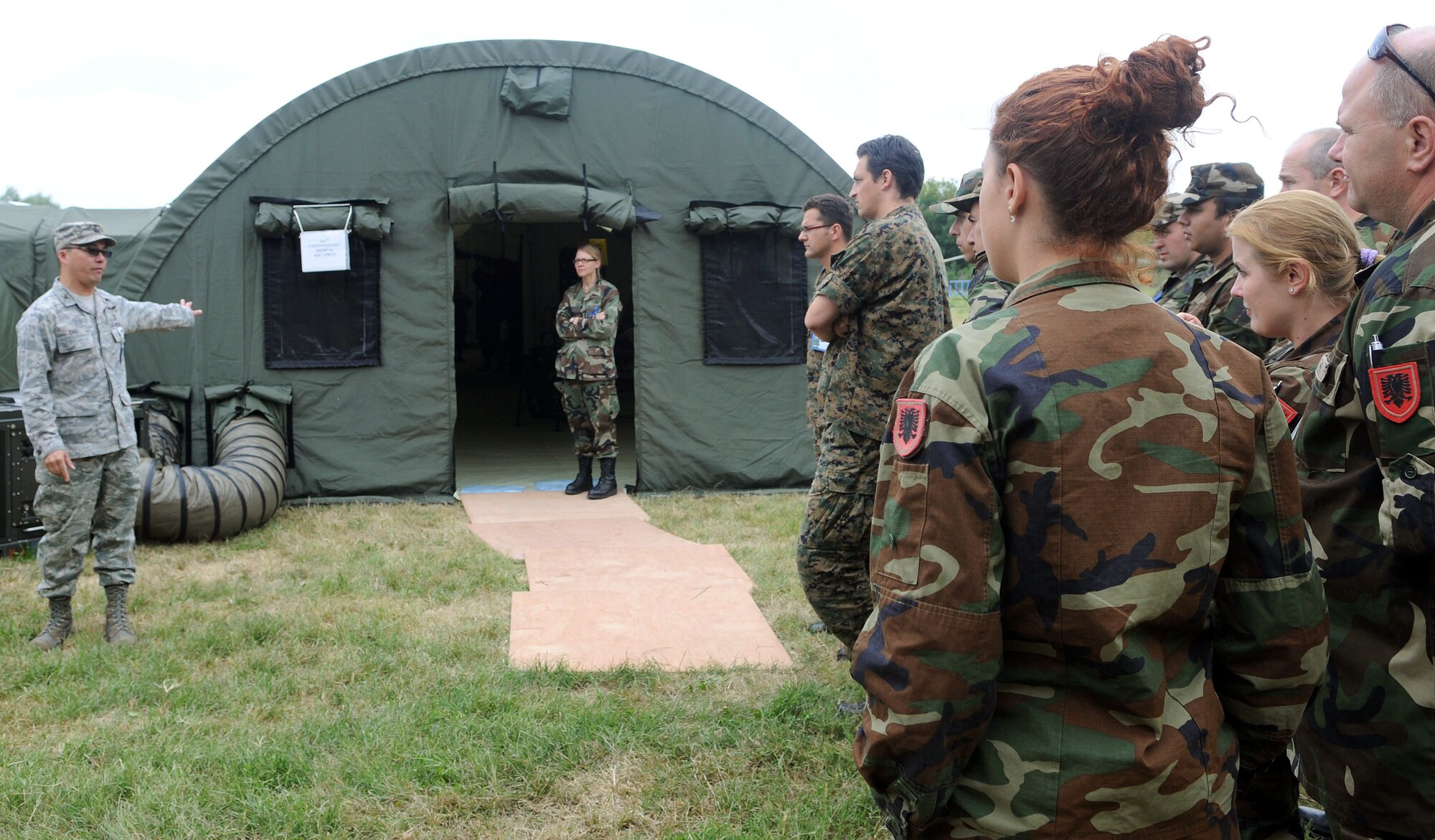 Col. John Chu welcomes multinational soldiers to the mobile hospital facility during an exercise orientation Sept. 8, 2009, in Nis, Serbia. The exercise, hosted by Serbia, provides a joint medical learning environment and assists host nation civilian and military services; international, private and volunteer organizations; and other participating nations in enhancing disaster response actions. Colonel Chu is the 458th Expeditionary Medical Squadron commander. (U.S. Air Force photo/Senior Airman Alex Martinez) 