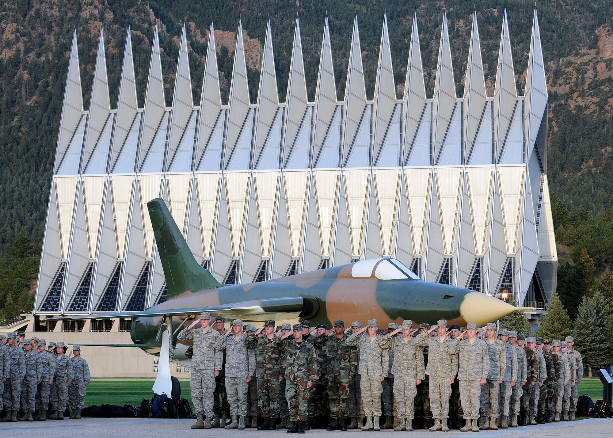 Cadet squadron 21 salutes during a reveille formation in honor of Patriot's Day and the Fallen Heroes of 9/11 at U.S. Air Force Academy, Colo., Sept. 11, 2009.  Behind them is an F-105 Thunderchief undergoing restoration.  (U.S. Air Force photo/Mike Kaplan)