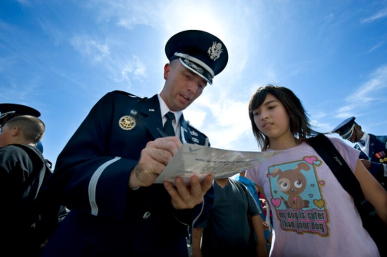 Lt. Col. Ray Powell signs autographs after a performance by the drill team during a visit to Rosa Parks Middle School in Sacramento, Calif., Sept. 10, 2009, for Air Force Week-Sacramento. Colonel Powell was a student of Rosa Parks Middle School from 1979-1981. Air Force Week-Sacramento is an event using various activities and exhibitions to educate the community about the Air Force's capabilities and missions. Colonel Powell is commander of the United States Air Force Honor Guard. (U.S. Air Force photo/Staff Sgt. Bennie J. Davis III)