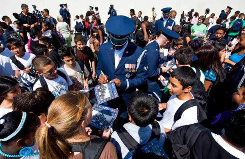 Airmen from the United States Air Force Honor Guard Drill Team sign autographs and pose for photos after their performance during a visit to Rosa Parks Middle School in Sacramento, Calif., Sept. 10, 2009, for Air Force Week-Sacramento. Air Force Week is an event using various activities and exhibitions to educate the community about the Air Force's capabilities and missions. (U.S. Air Force photo/Staff Sgt. Bennie J. Davis III)