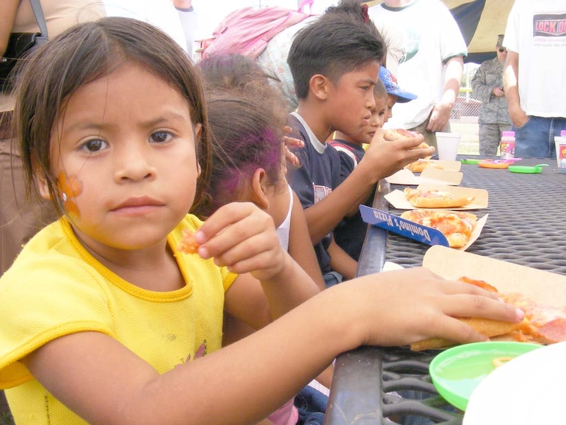 SOTO CANO AIR BASE, Honduras — Childern ate a free lunch of pizza and hot dogs during the Joint Task Force-Bravo’s “kid’s day” Sept. 10 near the base soccer field. More than 100 children from local orphanages were transported to base for the event. The children participated in a variety of events the volunteers organized including a HH-60 Blackhawk static display, military working dog demonstration and fire truck display. The children also got to participate in soccer, kickball and a water balloon toss. The children were given a “goodie” bag containing small toys and candy as the left base (U.S. Air Force photo/Martin Chahin).