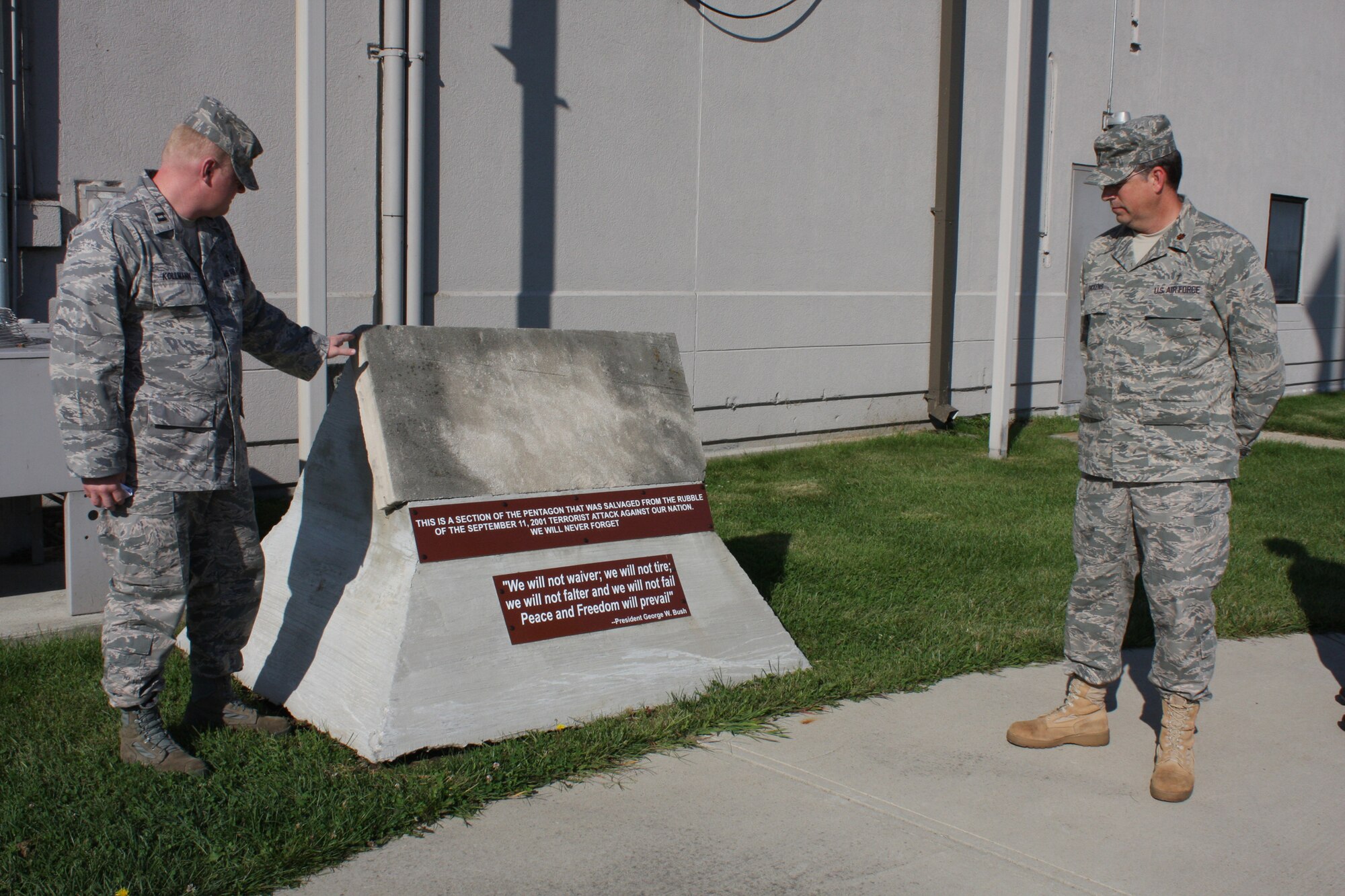 WRIGHT-PATTERSON AIR FORCE BASE, Ohio – Chaplain (Capt.) Jonathan Kollmann, left, and Chaplain (Maj.) William Dickens, Jr., both from the 445th Airlift Wing Chaplain’s Office, pause in front of a section of the Pentagon that was salvaged from the rubble on Sept. 11, 2001, to honor and remember those who lost their lives eight years ago when the Pentagon was struck by hijacked American Airlines Flight 77 at 9:43 a.m. A remembrance service with members from the wing was held at the flagpole outside the wing headquarters building to honor and remember those who lost their lives that day.  The piece was donated to the wing, and is on display at the flagpole.  (U. S. Air Force photo/Stacy Vaughn)