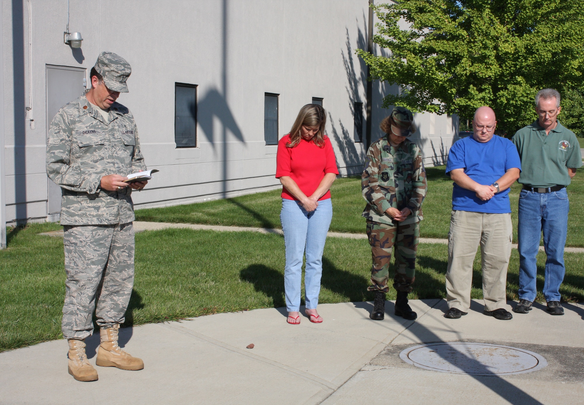 WRIGHT-PATTERSON AIR FORCE BASE, Ohio – Chaplain (Maj.) William Dickens, Jr., Senior Chaplain, 445th Airlift Wing, says a prayer during a Sept. 11 remembrance service with members of the wing Sept. 11 at the flagpole outside the wing headquarters building.  The service was held at 9:43 a.m. to remember and honor those who lost their lives at that precise moment in time eight years ago when the Pentagon was struck by hijacked American Airlines Flight 77. (U. S. Air Force photo/Stacy Vaughn)