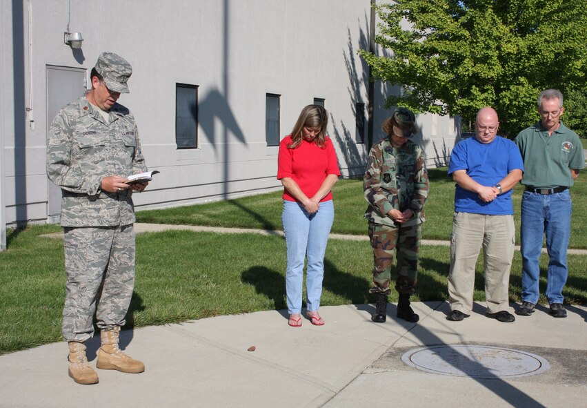 WRIGHT-PATTERSON AIR FORCE BASE, Ohio – Chaplain (Maj.) William Dickens, Jr., Senior Chaplain, 445th Airlift Wing, says a prayer during a Sept. 11 remembrance service with members of the wing Sept. 11 at the flagpole outside the wing headquarters building.  The service was held at 9:43 a.m. to remember and honor those who lost their lives at that precise moment in time eight years ago when the Pentagon was struck by hijacked American Airlines Flight 77. (U. S. Air Force photo/Stacy Vaughn)