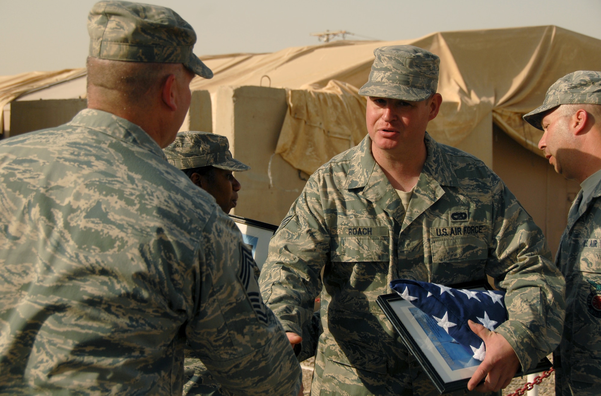 JOINT BASE BALAD, Iraq -- Staff. Sgt Robert Roach, 332nd Expeditionary Logistics Readiness Squadron ramp team chief, shakes hands with Chief Master Sgt. Lawrence Rettele, 332nd Expeditionary Security Forces Group superintendent, during a Last Alarm ceremony at the fire station here Sept. 11, 2009. Sergeant Roach, a Reservist deployed here from the 88th Aerial Port Squadron at McGuire Air Force Base, N.J., also serves as a firefighter for the Fire Department of New York. He was one of the first responders to the World Trade Center after the terrorist attacks Sept. 11, 2001. (U.S. Air Force photo/Senior Airman Nicole Enos)