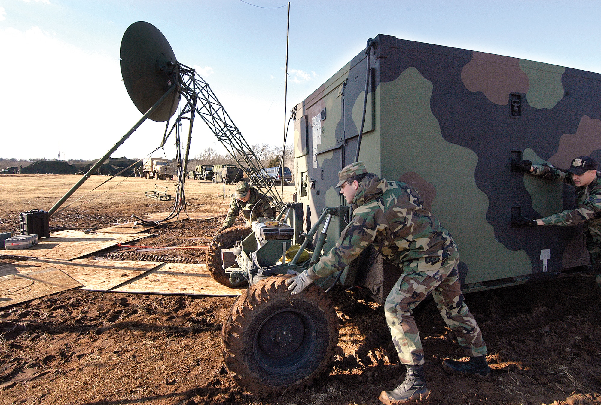 Airmen from the 3rd Combat Communications Group move a TRC-170 through the mud into position at the Glenwood Training Area during a 2008 joint exercise with the Army.  Fort Sill Soldiers set up in the distance. (Air Force photo by Margo Wright) 
