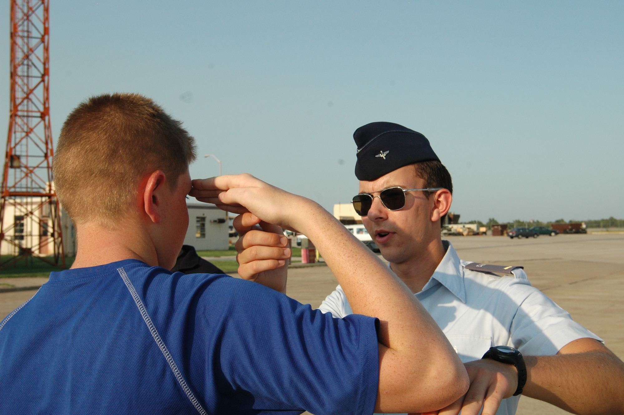 Civil Air Patrol 2nd Lt. Ryan Jones gives pointers to a new CAP recruit on the proper way to salute during a formation at their weekly meeting in Bldg. 240 here. During the meeting the cadets cover current events and brush up on aerospace education topics. (Air Force photo by Howdy Stout)