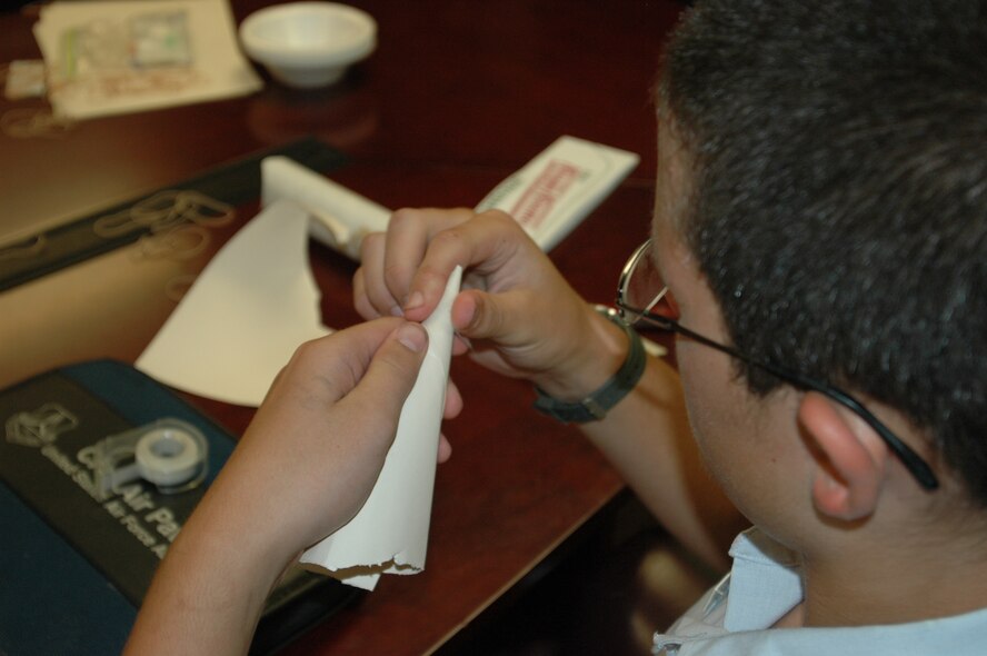 A Civil Air Patrol cadet fashions the nose cone for his “junk rocket” during their weekly meeting in Bldg. 240 here. The cadets in CAP learn the fundamentals of flight and the junk rocket project allows them to put physics into practice.(Air Force photos by Howdy Stout)