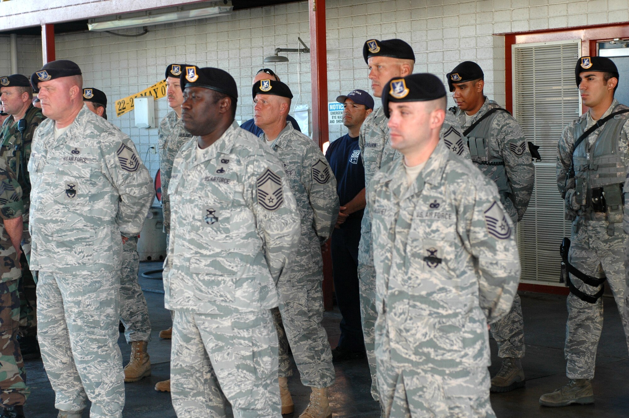 Airmen from the 162nd Security Forces Squadron here stand in formation in the base fire station to remember the Sept. 11, 2001, terrorist attacks on the United States exactly eight years after the fateful day. Squadron members wore a black piece of tape over their badges as a symbol of mourning for 1st Lt. Joseph Helton, Jr., a Security Forces officer killed by an improvised explosive device in Baghdad, Iraq, while on patrol, Sept. 8. Lieutenant Helton was deployed from the 6th Security Forces Squadron out of MacDill Air Force Base, Fla. (Air National Guard photo by Maj. Gabe Johnson)