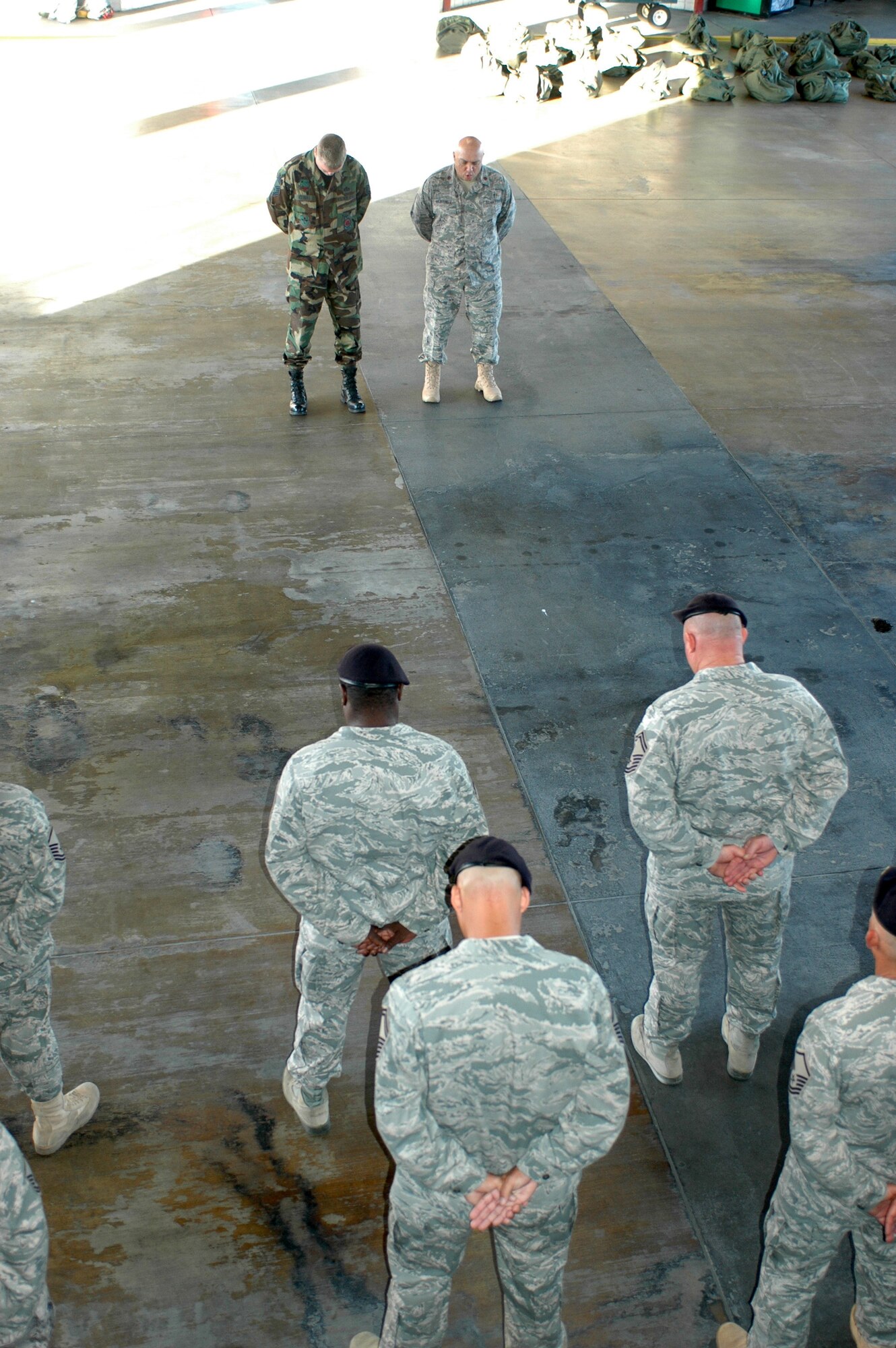 Members of the 162nd Fighter Wing at Tucson International Airport share a moment of silence in the base fire station to remember the Sept. 11, 2001, terrorist attacks on the United States exactly eight years after the fateful day. Chaplain (Maj.) Mike Martinez, upper right, and Senior Master Sgt. Shane Clark, base fire chief, led the wing in a prayer for all the lives lost and the families affected by the attacks. (Air National Guard photo by Maj. Gabe Johnson)