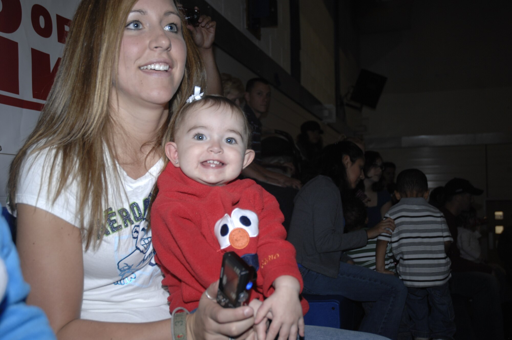 Briley Murry (in the Elmo sweatshirt), daughter of Staff Sgt. Brian Murry of the 488th Intelligence Squadron at RAF Mildenhall, England, and her mother Rachel enjoy the Elmo and Friends show RAF Lakenheath on Sept. 10, 2009. The Sesame Workshop, working with the USO, is travelling through bases in Europe, Alaska and Hawaii doing shows with a 'military parents' theme. (U.S. Air Force photo by Tech. Sgt. Chris Stagner)