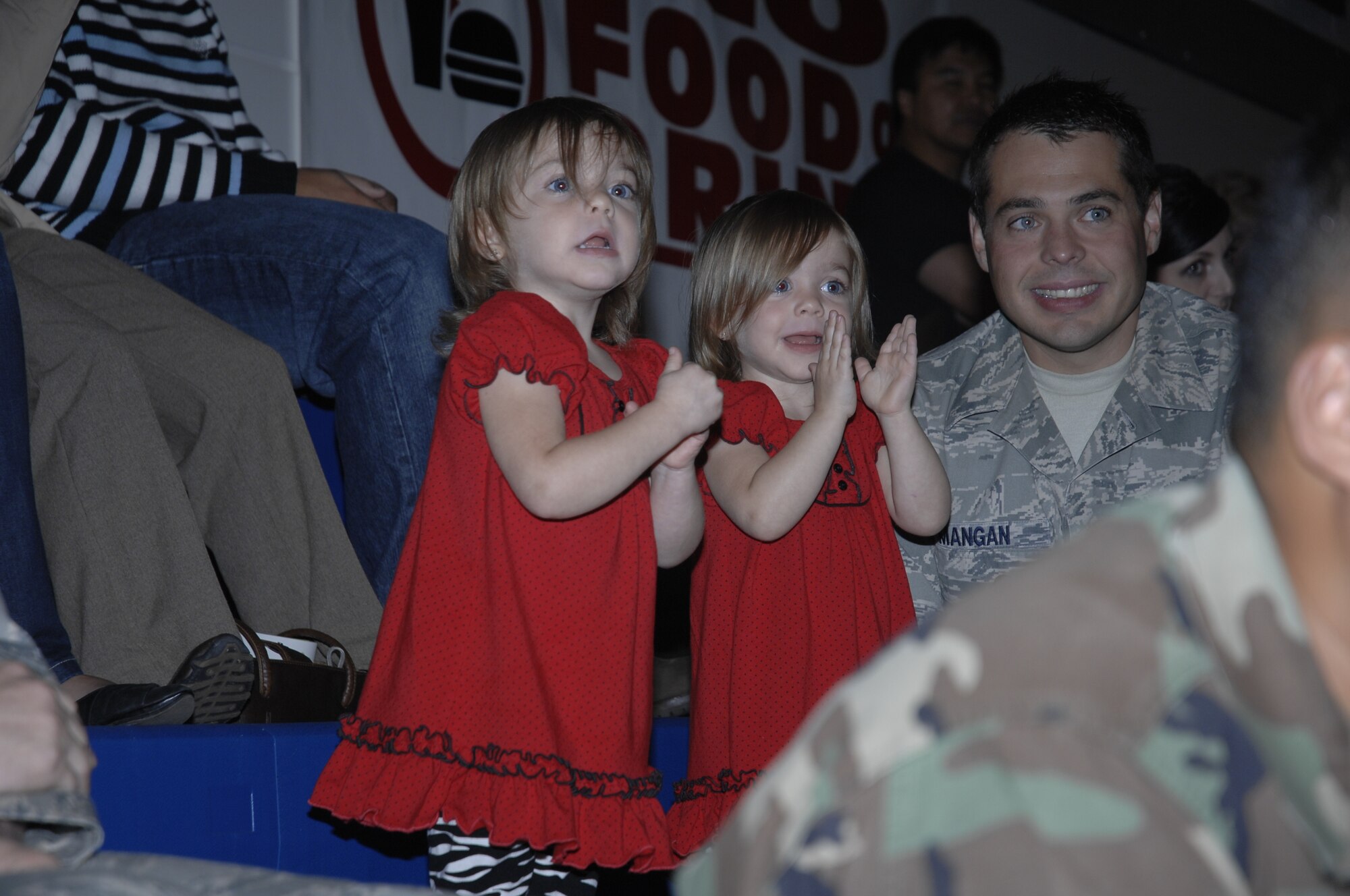 Emily and Eleanor, with their father Staff Sgt. Daniel Mangan, 48th Medical Support Squadron Lab technician, dance to the songs being sung by Elmo and Friends at RAF Lakenheath on Sept. 10, 2009. The Sesame Workshop, working with the USO, is travelling through bases in Europe, Alaska and Hawaii doing shows with a 'military parents' theme. (U.S. Air Force photo by Tech. Sgt. Chris Stagner)