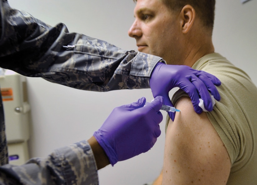 Staff Sgt. James Barnett, 779th Medical Operations Squadron medical technician, administers the flu vaccination to Col. Christopher Kenny, Air Force District of Washington deputy chief of the basing division, at Malcolm Grow Medical Center Sept. 2. The 779th Medical Group is expecting to vaccinate over 12,000 installation members during the 2009 flu season. (U.S. Air Force photo/ Staff Sgt. Renae Kleckner)