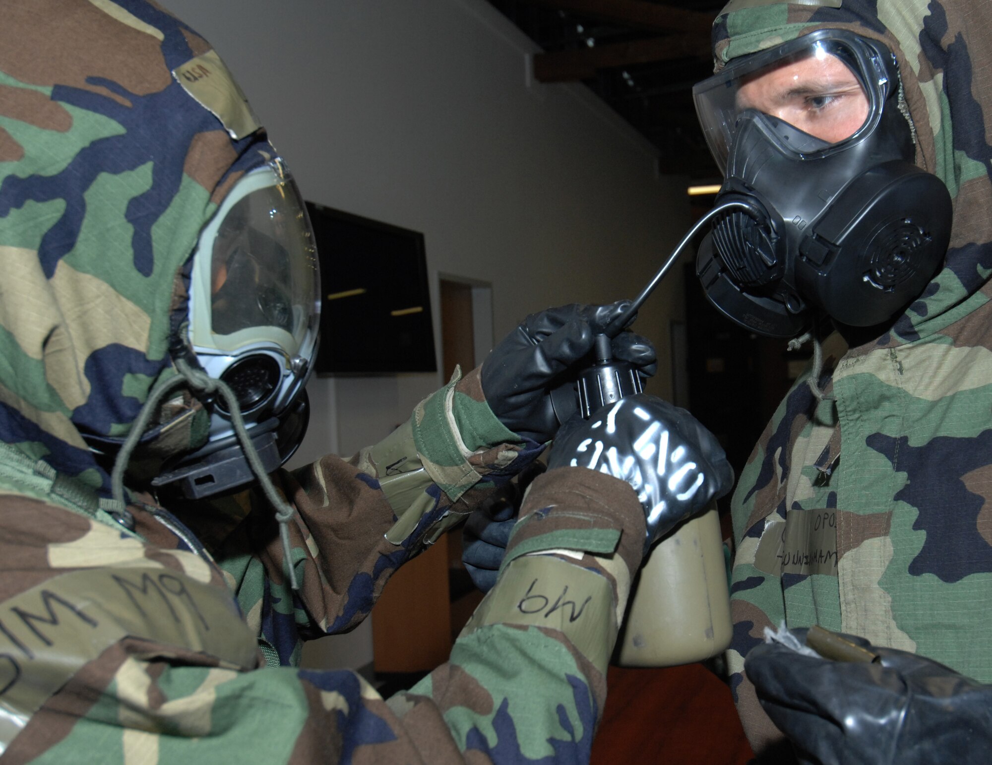 SPANGDAHLEM AIR BASE, Germany – Tech. Sgt. Jeffrey Cunningham, 52nd Civil Engineer Squadron, uses the buddy system to practice drinking through his chemical-biological mask using a canteen during a chemical, biological, radiological and nuclear class Sept. 9. Airmen learn how to drink water with their masks on to stay hydrated should they have to wear mission oriented protective posture 4 for a long period of time.  (U.S. Air Force photo/Airman 1st Class Staci Miller)