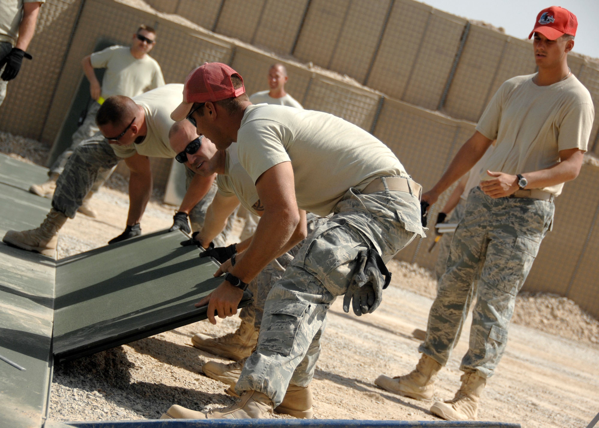 Civil engineers from the 451st Expeditionary Civil Engineer Squadron and the Rapid Engineer Deployable Heavy Operational Repair Squadron Engineers work together to lay AM2 mats at Panther Ramp here, Sept. 10, 2009. AM2 Mats are often used for temporary landing stips in deployed environments but are as useful in several situations. (U.S. Air Force photo/Senior Airman Timothy Taylor)