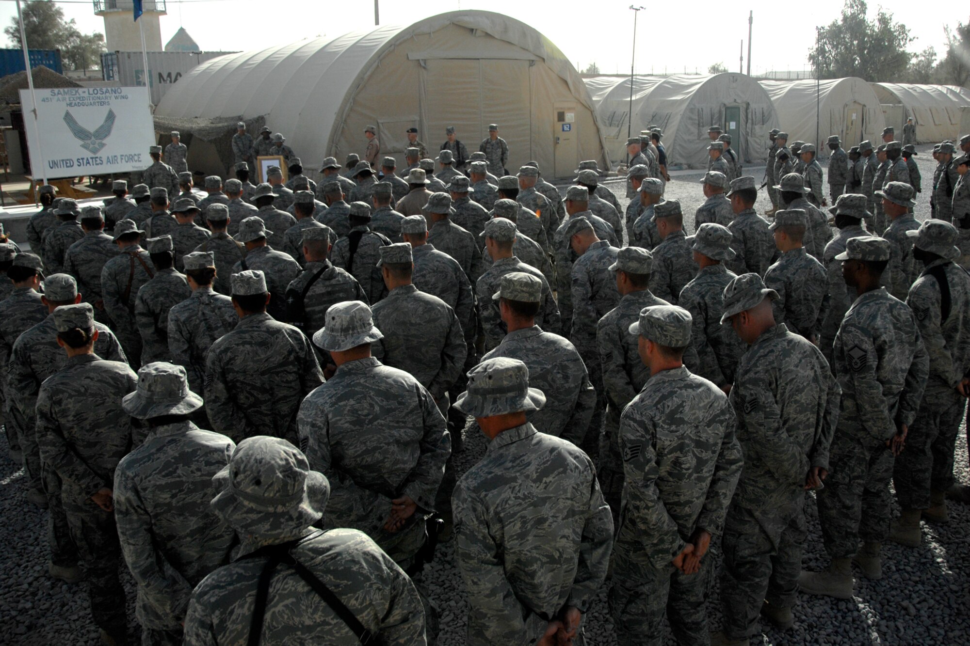 Members of the 451st Air Expeditionary Wing stand at ease while Tech. Sgt. Pamela Bell reads the poem "Remember September" by Andrew St. Wilson in honor of those who died on Sept. 11, 2001, here, Sept. 11, 2009. Sergeant Bell performed self-aid and buddy care to those who were injured during the attack at the Pentagon. More than 100 people stood in formation to remember those who fell on the day the Twin Towers fell and to honor those who sacrificed their lives on Flight 93 so others may live. Sergeant Bell is a Knowledge Operations Manager with the 451st Air Expeditionary Wing command staff.  Her home station is Holloman AFB, N.M., and she hails from Sedalia, Mo. (U.S. Air Force photo/Senior Airman Timothy Taylor)