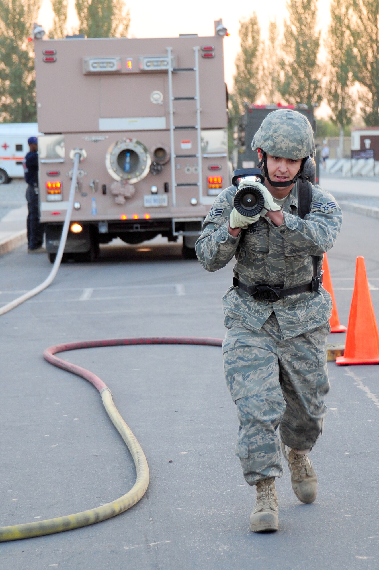 TRANSIT CENTER AT MANAS, Kyrgyzstan -- Senior Airman Phillip Acord, 376th Expeditionary Civil Engineer Squadron quality assurance enforcer, performs the hose advancements drill as part of the Fire Fighter Challenge at the Transit Center. Ten Airmen participated in the foot race against the clock. (U.S. Air Force photo/Senior Airman Steele C. G. Britton)