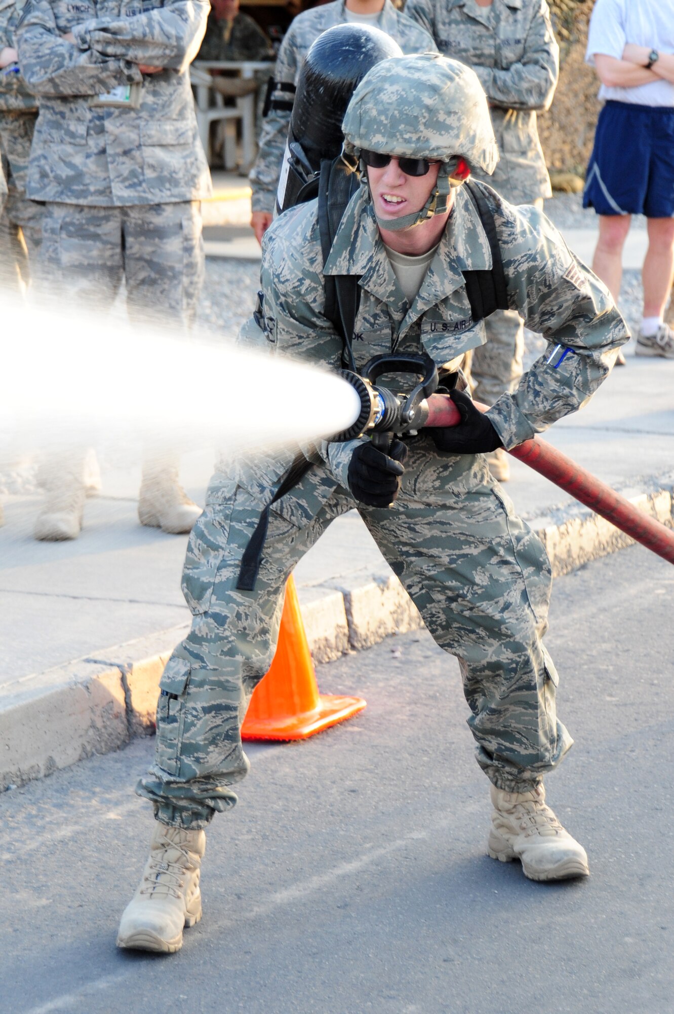 TRANSIT CENTER AT MANAS, Kyrgyzstan -- Staff Sgt. Matthew Zook, 376th Air Expeditionary Wing financial management customer service technician, releases water from a hose as the final task of the Fire Fighter Challenge at the Transit Center. Water was pumped out at one-hundred gallons per minute until the participant knocked put out a simulated fire and stopped the clock. (U.S. Air Force photo/Senior Airman Steele C. G. Britton)
