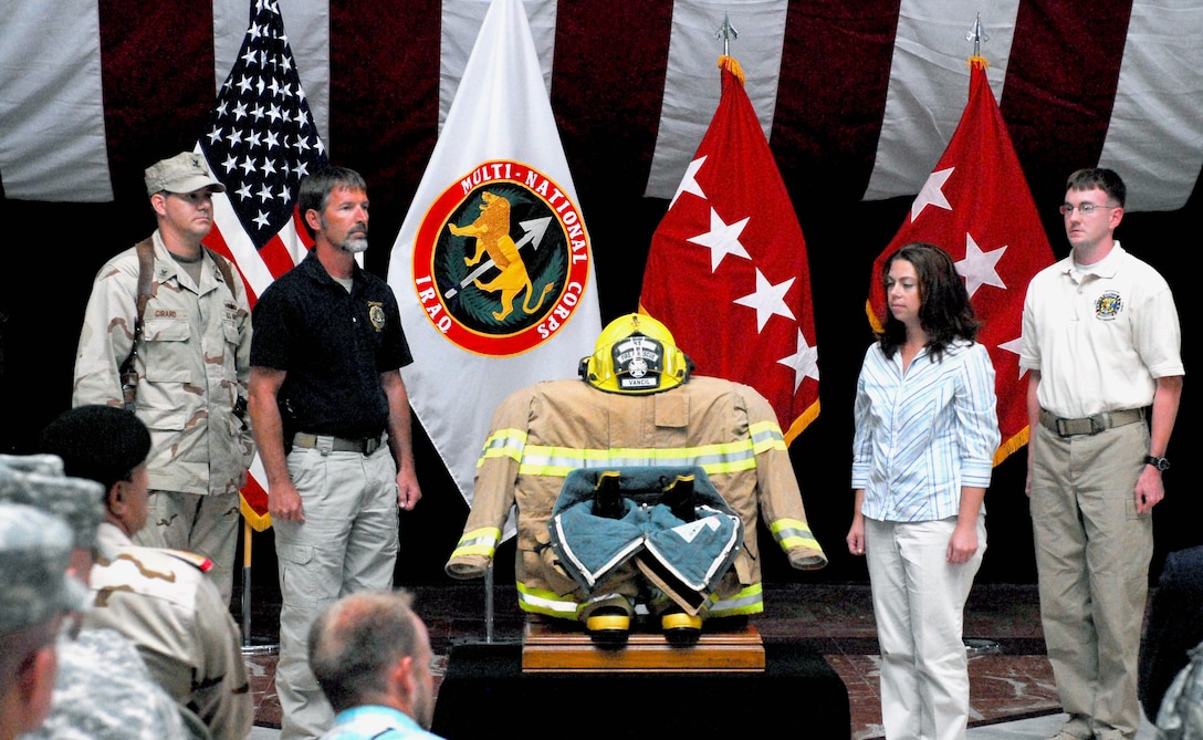 Troops, fire department personnel and civilians participate in a tribute to those that lost their lives during a 9/11 remembrance ceremony held at Al Faw Palace on Camp Victory, Baghdad, Sept. 11, 2009.