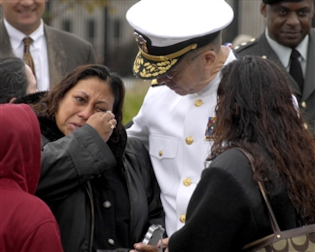 Chairman of the Joint Chiefs of Staff Adm. Mike Mullen comforts a family member at the Pentagon Memorial during the 8th anniversary ceremony on Sept. 11, 2009.  The passage of eight years cannot diminish the terrible memories of Sept. 11, 2001.  