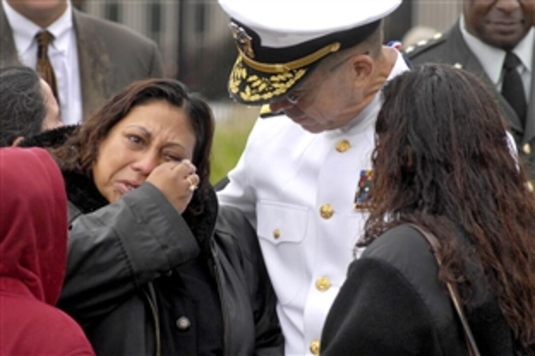 U.S. Navy Adm. Mike Mullen, chairman of the Joint Chiefs of Staff, comforts a family member after the the 9/11 commemoration ceremony at the Pentagon Memorial, Sept. 11, 2009.  