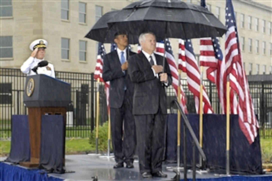 President Barack Obama, center, Defense Secretary Robert M. Gates, right, and Navy Adm. Mike Mullen, chairman of the Joint Chiefs of Staff, salute under rainy skies before a wreath-laying ceremony during the 9/11 remembrance ceremony at the Pentagon Memorial, Sept. 11, 2009.  