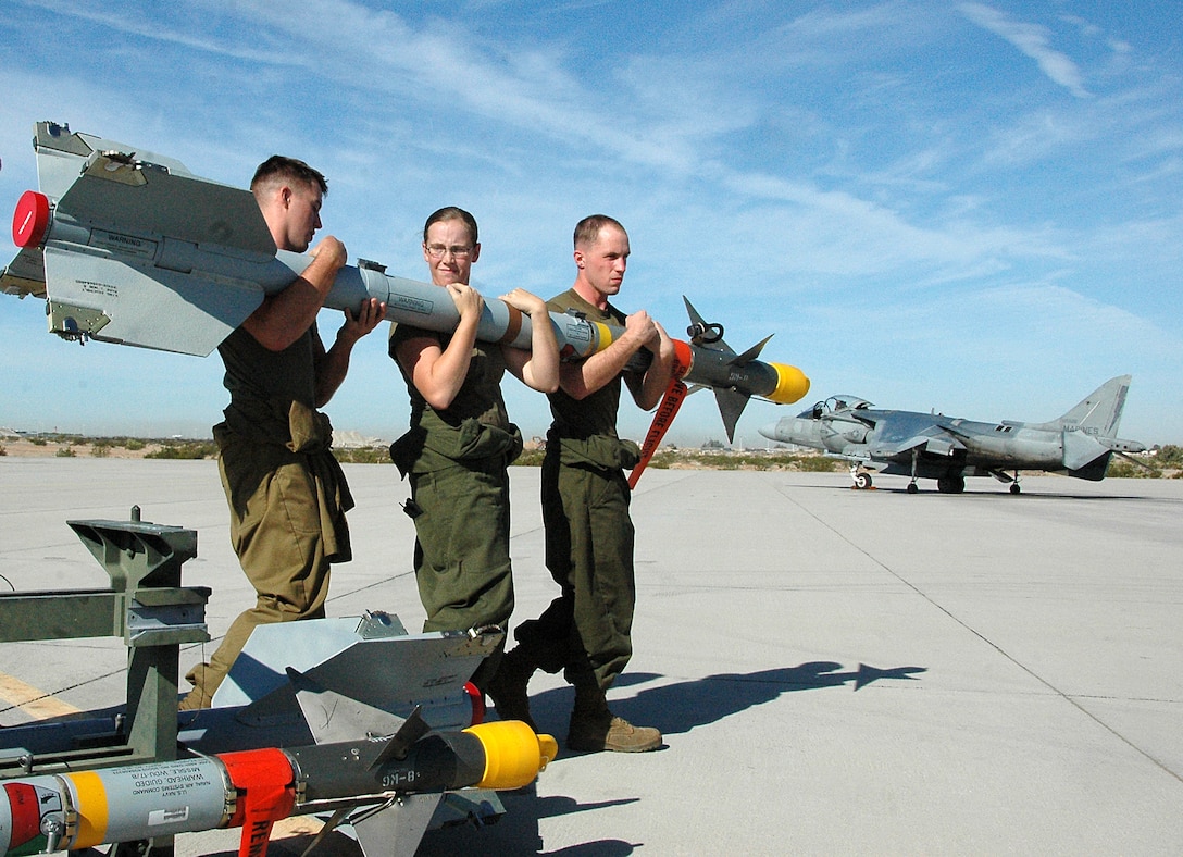 Pvt. Taylor Martin, right, Lance Cpl. Erin Donahue and Lance Cpl. Tyler Kohl, Marine Attack Squadron 311 ordnance technicians, carry a Sidewinder missile to an AV-8B Harrier on the flight line at the Marine Corps Air Station in Yuma, Ariz., Sept. 11, 2009. The squadron fired four Sidewinder missiles at parachute flares off the coast of San Diego for air-to-air combat training that afternoon. Though the Harrier is primarily used for air-to-ground strikes, the squadron also trains with dummy missiles. This was, however, the first time the squadron has fired live missiles in more than two years. “Since air-to-air is one of our missions, it’s important to maintain proficiency,” said Capt. Eric Fong, one of the two squadron pilots to fire the missiles. “It’s one thing to train with a training weapon and another to actually employ the real weapon.”