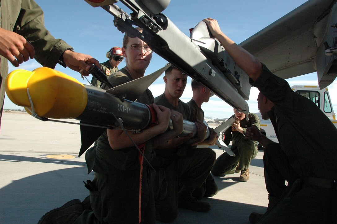 Lance Cpl. Tyler Kohl, left, Lance Cpl. Erin Donahue and Pvt. Taylor Martin, Marine Attack Squadron 311 ordnance technicians, attach a Sidewinder missile to the wing of an AV-8B Harrier on the flight line at the Marine Corps Air Station in Yuma, Ariz., Sept. 11, 2009. The squadron fired four Sidewinder missiles at parachute flares off the coast of San Diego for air-to-air combat training that afternoon. Though the Harrier is primarily used for air-to-ground strikes, the squadron also trains with dummy missiles. This was, however, the first time the squadron has fired live missiles in more than two years. “Since air-to-air is one of our missions, it’s important to maintain proficiency,” said Capt. Eric Fong, one of the two squadron pilots to fire the missiles. “It’s one thing to train with a training weapon and another to actually employ the real weapon.”