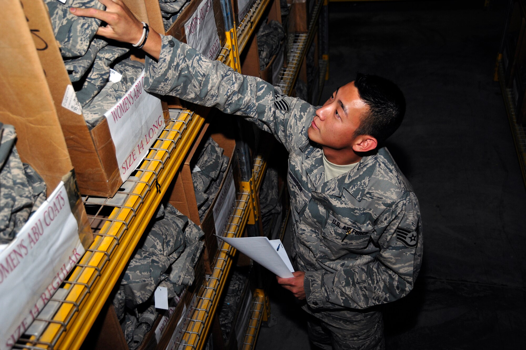 SOUTHWEST ASIA -Staff Sgt. Derrick Johnson, 380th Expeditionary Logistics Readiness Squadron, grabs an Airman battle uniform blouse for issue Sept. 12, 2009. Sergeant Johnson is deployed from Royal Air Force Mildenhall, United Kingdom, and grew up in Arlington, Texas. (U.S. Air Force photo/Tech. Sgt. Charles Larkin Sr) 