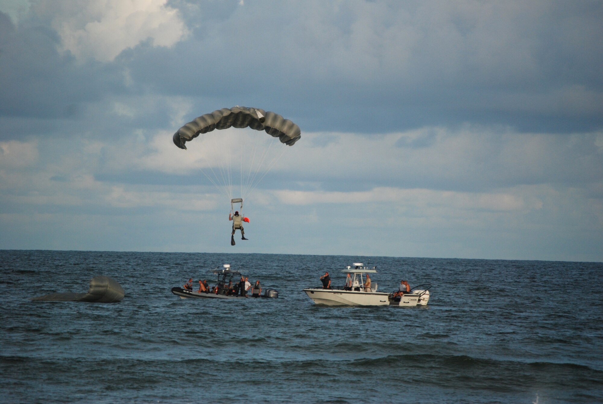 COCOA BEACH, Fla. -- An Air Force Reserve pararescuemen parachutes to his landing zone near boats from the 308th Rescue Squadron as part of a rescue demonstration in front of local civic leaders, citizens of and visitors to the Cocoa Beach community and military members during a ceremony honoring military men and women, both past and present from the area Sept. 11. The 920th Rescue Wing conducted a Search and Rescue operation involving Pararescuemen parachuting from unit-equipped HC-130P/N aircraft into the ocean and a rescue operation with the unit's HH-60G Pave Hawk helicopter which also performed during a air-to-air refueling demonstration with the HC-130P/N. The 920th Rescue Wing will conduct similar capability demonstrations during the Cocoa Beach air show scheduled for October 2-4 at Alan Shepard Park along Highway A1A in. U.S. Air Force photo/Master Sgt. Bryan Ripple