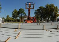 Jeremy McBay (foreground) helps Elijah Skinner, MGC Roofing and Construction, lower the bundle of roof panels to the stack in the parking lot of the 919th Special Operations Wing headquarters building Sept. 4 at Duke Field.  The workers off-loaded approximately 1,000 panels to be cut and shaped before they are used to cover the headquarters building.  (U.S. Air Force photo/Staff Sgt. Samuel King Jr.)