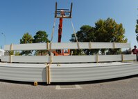 Jeremy McBay (right), MGC Roofing and Construction, guides the roof panels to the stack in the parking lot of the 919th Special Operations Wing headquarters building Sept. 4 at Duke Field.  The workers off-loaded approximately 1,000 panels to be cut and shaped before they are used to cover the headquarters building.  (U.S. Air Force photo/Staff Sgt. Samuel King Jr.)