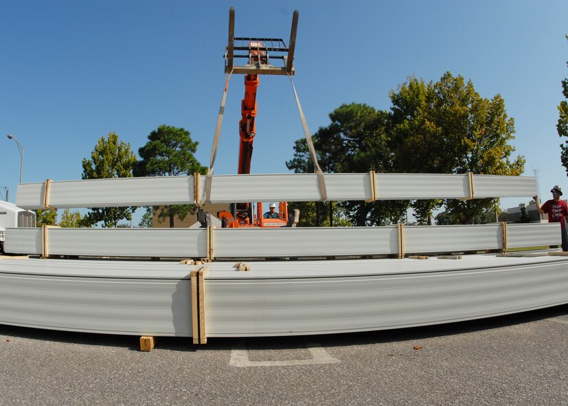 Jeremy McBay (right), MGC Roofing and Construction, guides the roof panels to the stack in the parking lot of the 919th Special Operations Wing headquarters building Sept. 4 at Duke Field.  The workers off-loaded approximately 1,000 panels to be cut and shaped before they are used to cover the headquarters building.  (U.S. Air Force photo/Staff Sgt. Samuel King Jr.)
