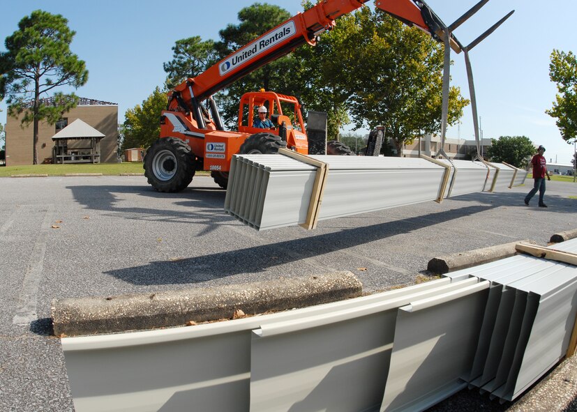 Jeremy McBay (right), MGC Roofing and Construction, guides the roof panels to the stack in the parking lot of the 919th Special Operations Wing headquarters building Sept. 4 at Duke Field.  The workers off-loaded approximately 1,000 panels to be cut and shaped before they are used to cover the headquarters building.  (U.S. Air Force photo/Staff Sgt. Samuel King Jr.)