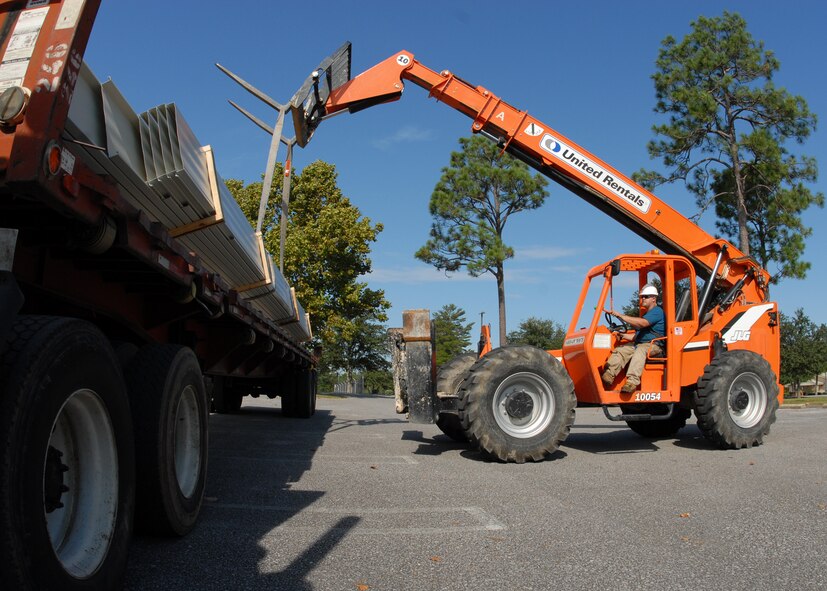 Elijah Skinner, MGC Roofing and Construction, lifts a bundle of roof panels off a flat-bed truck to be used to roof the 919th Special Operations Wing headquarters building Sept. 4 at Duke Field.  The construction workers off-loaded approximately 1,000 panels that day.  (U.S. Air Force photo/Staff Sgt. Samuel King Jr.) 
