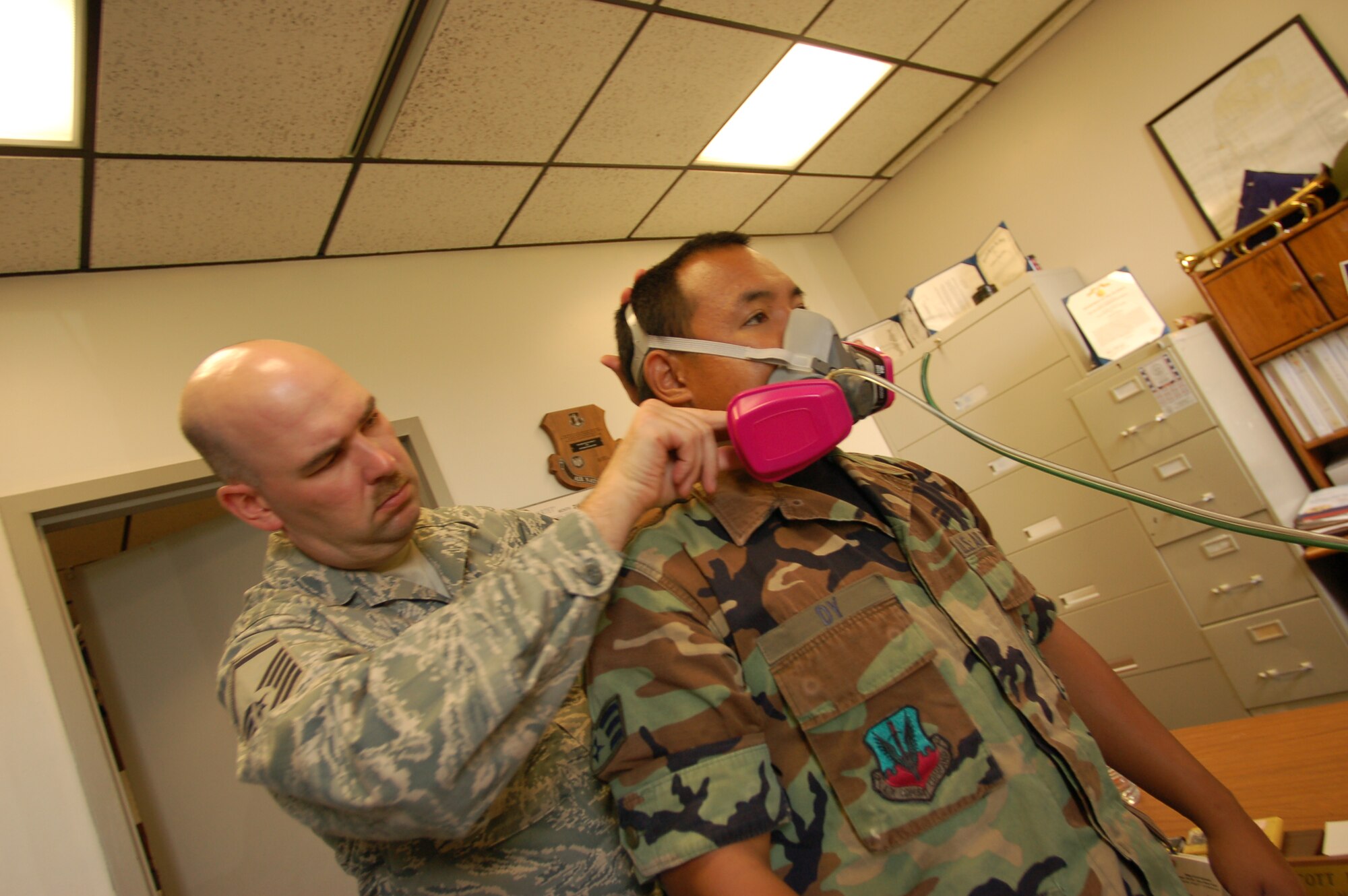 Senior Airman Dion Richardson observes as Bill Hoerle, environmental analyst, 103rd Civil Engineering and Senior Airman Kent Cremer, bio-environmental engineer, 103rd Medical Group, draw a sample of hazardous waste in a siphon at Bradley ANG Base, East Granby, Conn. to be sent off for testing. The results determine how to safely dispose of the waste in accordance with environmental regulations. (U.S. Air Force photo by Tech. Sgt. Josh Mead)
