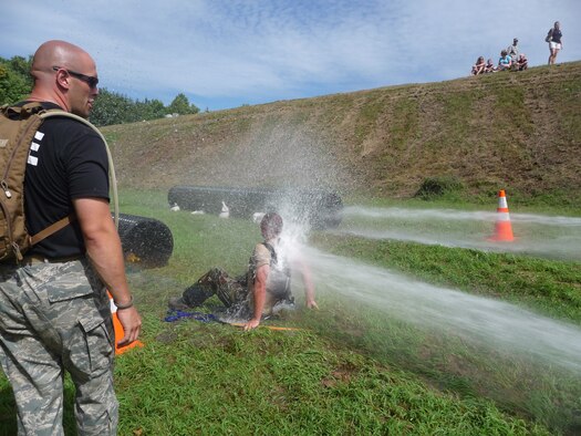 Staff Sgt. Bill Beeler watches Master Sgt. James Reynolds block the force of a fire hose to allow the other team members easier access crawling through an obstacle during the CT SWAT Challenge in West Hartford, Conn. Aug. 27, 2009.  (Photo courtesy of Staff Sgt. Jessica Roy) 
