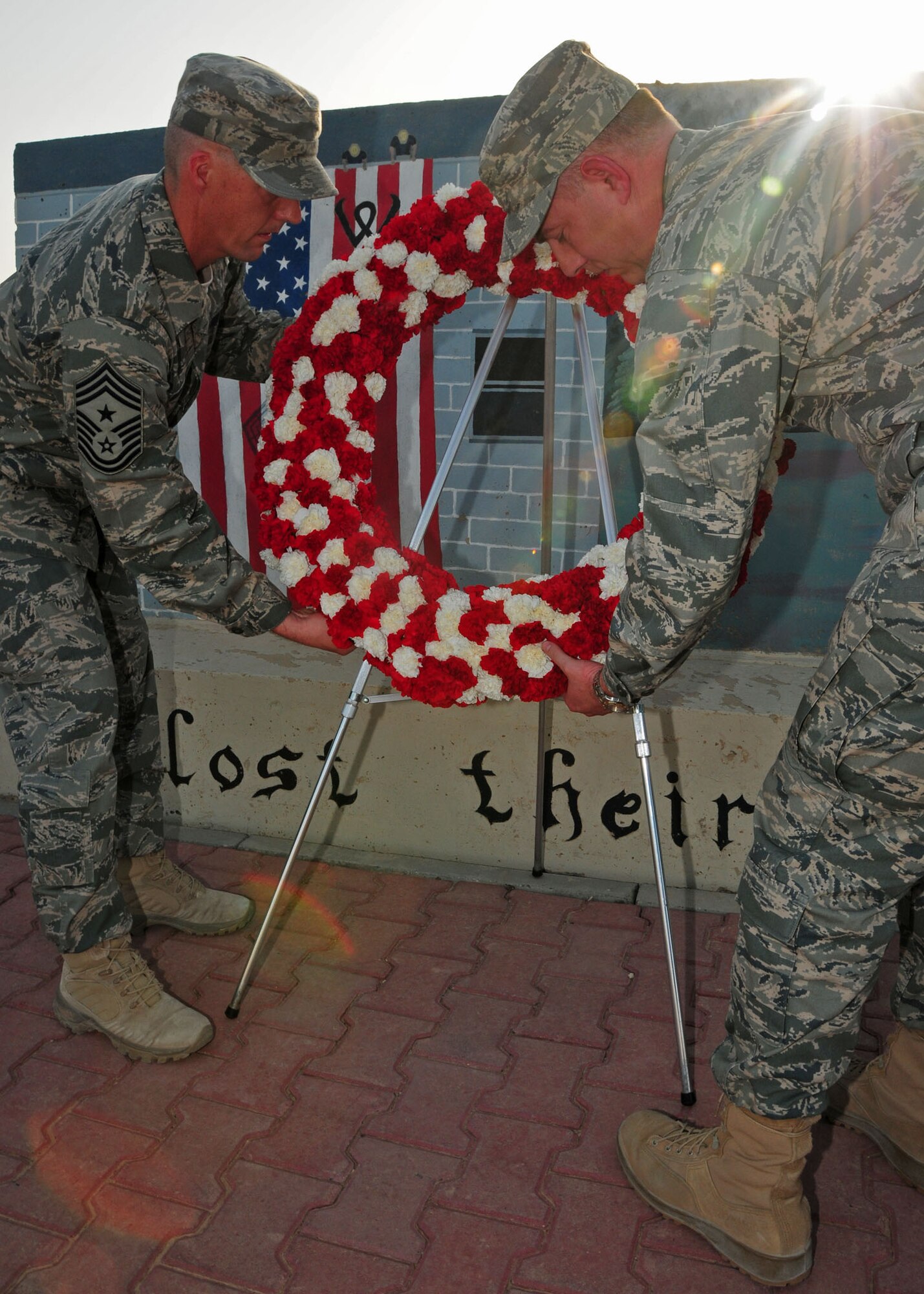 SOUTHWEST ASIA -- Chief Master Sgt. Douglas McIntyre, 386th Air Expeditionary Wing command chief, and Col. John R. Gordy II, 386th AEW commander, place a wreath at an air base in Southwest Asia during a Sept. 11, 2009 ceremony to honor the memory of those who died in the attacks of Sept. 11, 2001.  (U.S. Air Force photo/Tech. Sgt. Tony Tolley)