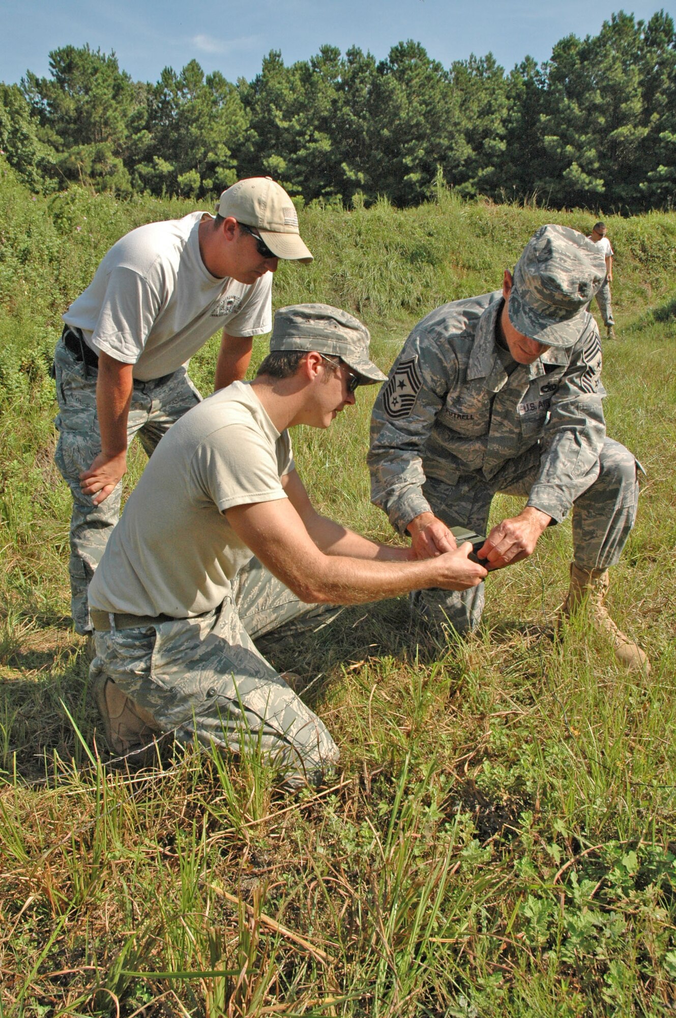 315th Airlift Wing Command Chief Master Sgt. Ben Futrell primes a charge with the assistance of Staff Sgt. Johnathan Sheridan and Tech. Sgt. Matt Reece, Explosive Ordinance Disposal Technicians with the 315th Civil Engineering Flight, at Charleston Air Force Base, S.C., Sept. 12. Command leadership decided to participate in the required demolitions training to experience a few aspects of what it means to be an EOD technician. (U.S. Air Force photo by Senior Airman Dani Pacheco)