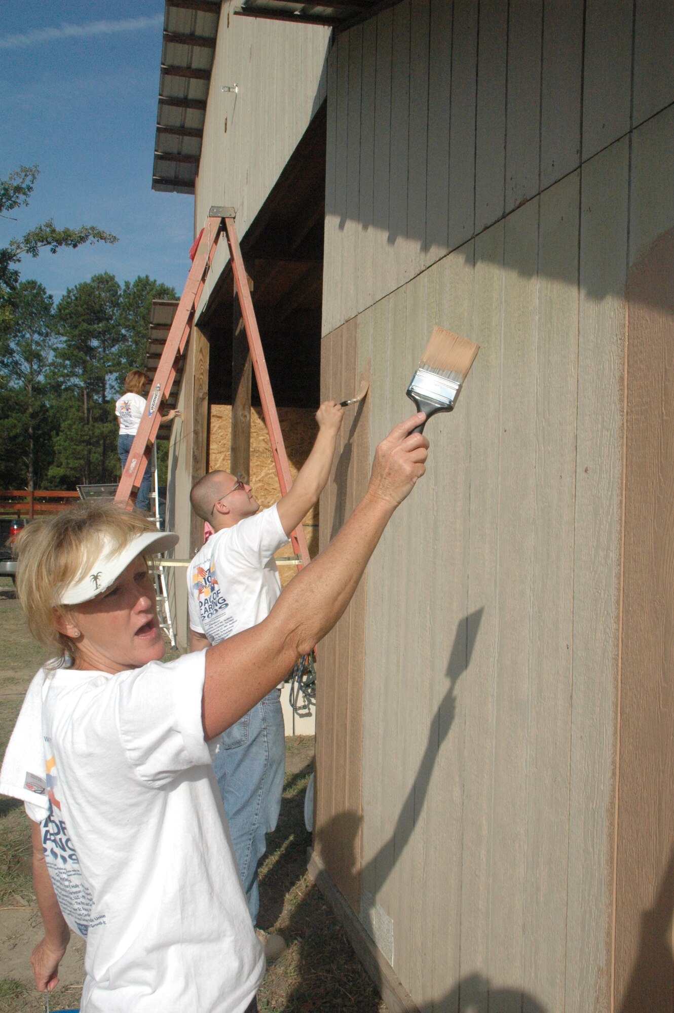 Connie Danbury from the 315th Operations Support Squadron volunteers to paint a barn at the Eagle Harbor Boys Ranch during the Day of Caring. (U.S. Air Force photo by Capt. Wayne Capps)