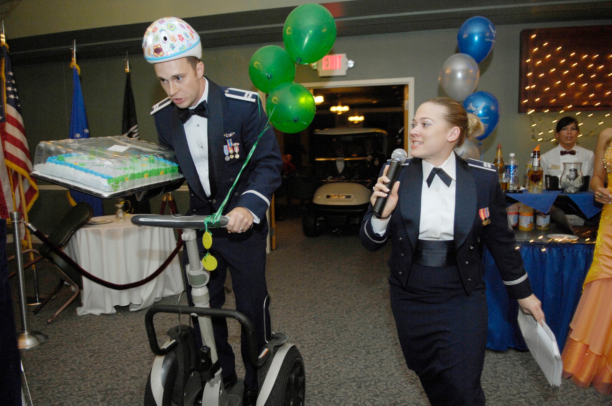 SHAW AIR FORCE BASE, S.C. -- Captain Christina Trace, 609th Air Intelligence Squadron, announces the arrival of Capt. Joshua Arki, 55th Fighter Squadron, during Shaw’s 62nd Air Force Birthday Ball, Sept. 12. Captain Arki delivered the first cake on a Segway before dropping it on the dance floor for the opening skit. (U.S. Air Force photo/Senior Airman Kathrine McDowell)