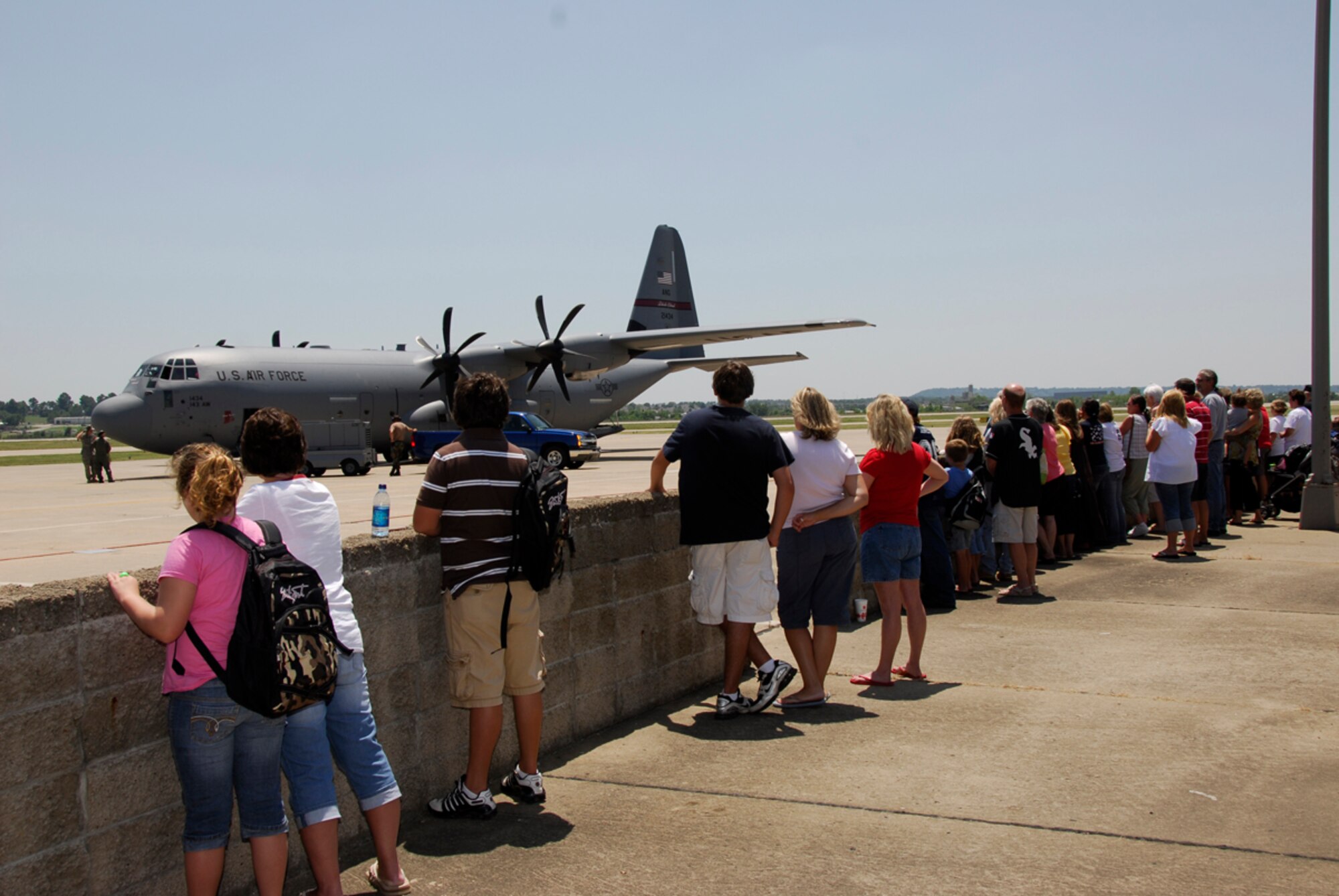Family members of the 188th Fighter Wing Civil Engineer Squadron await the taxi of a C-130 at the 188th July 24 prior to the 188th CES' departure from Fort Smith, Ark., for a six-month deployment to Guantanamo Bay, Cuba. The 188th CES deployed approximately 50 personnel to Guantanamo Bay. (U.S. Air Force photo by Senior Master Sgt. Dennis Brambl/188th Fighter Wing Public Affairs)