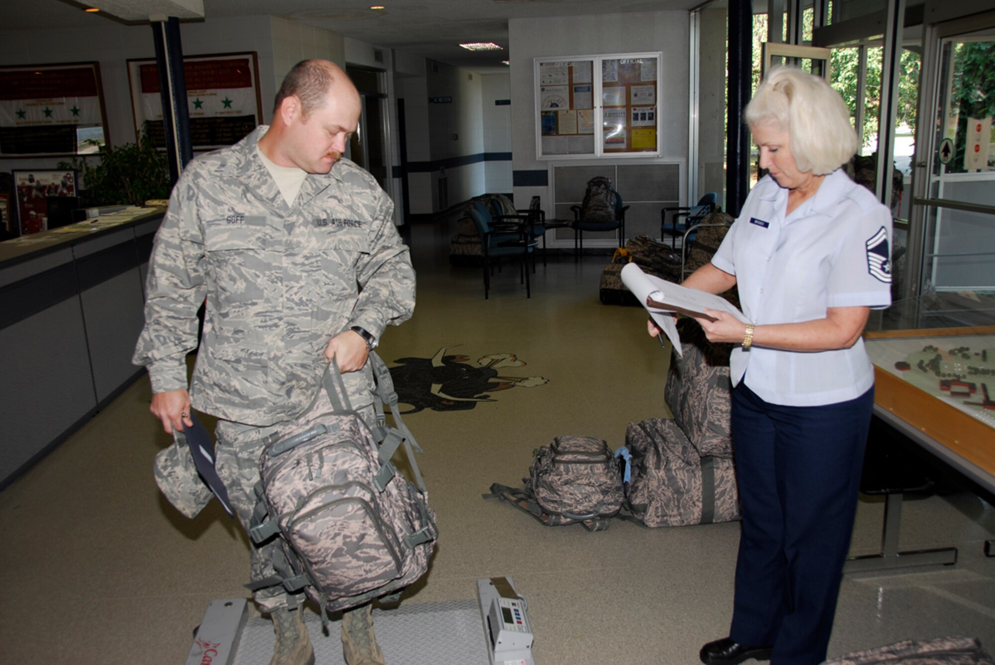 Staff Sgt. Gary Goff, a member of the 188th Fighter Wing's Civil Engineer Squadron, is weighed in by Senior Master Sgt. Susan Bridges, a member of the 188th's Deployment and Distribution Flight, at the 188th July 24 prior to departing Fort Smith, Ark., for a six-month deployment to Guantanamo Bay, Cuba. The 188th CES deployed approximately 50 personnel to Guantanamo Bay. (U.S. Air Force photo by Senior Master Sgt. Dennis Brambl/188th Fighter Wing Public Affairs)