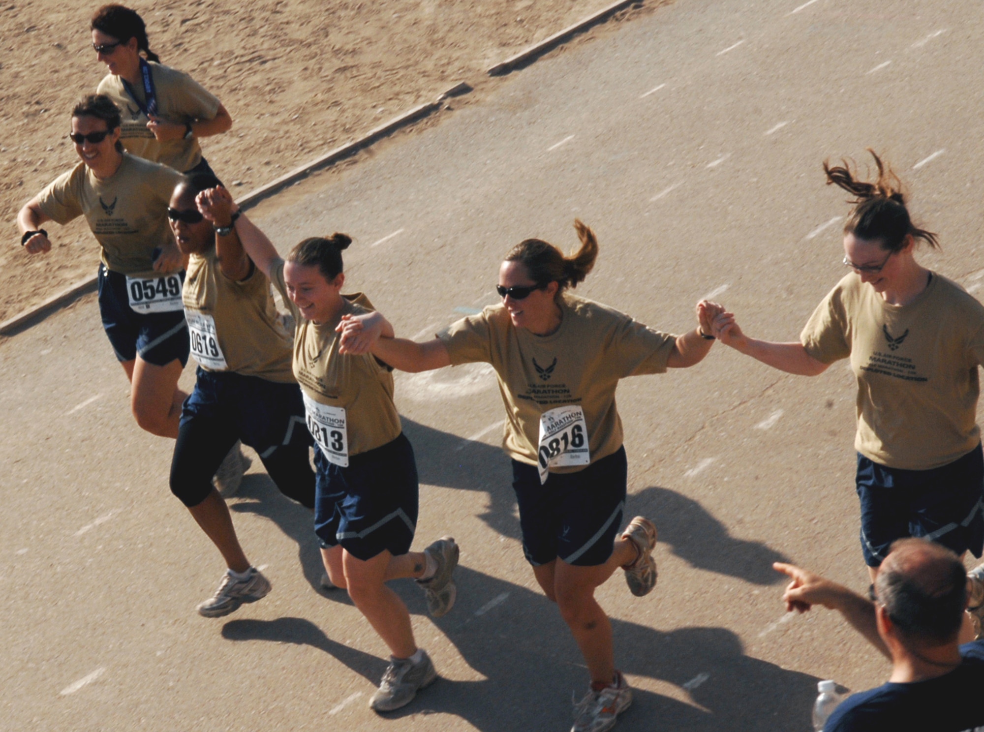 JOINT BASE BALAD, Iraq - United States Air Force Airmen hold hands as they make their way toward the finish line together during the Air Force Half Marathon at Holt Stadium here Sept. 11, 2009. Approximately 600 servicemembers and contractors run in the event. (U.S. Air Force photo/Senior Airman Christopher Hubenthal)
