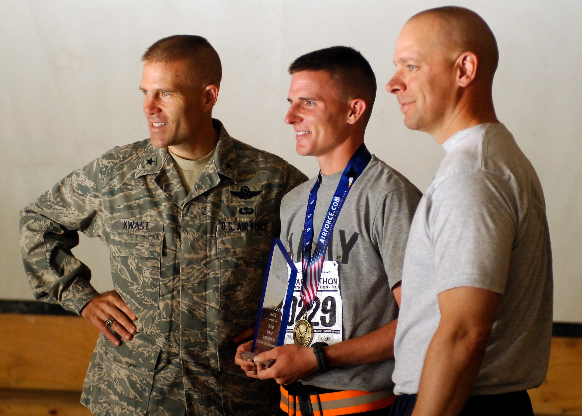 BAGRAM AIRFIELD, Afghanistan -- Brig. Gen Steven Kwast, 455th Air Expeditionary Wing commander, presented the victor's trophy to Army Sgt. Brian Butzler, the winner in the men's division of the Air Force Half Marathon. Chief Master Sgt. Dennis Vannorsdall, 455th Air Expeditionary Wing command chief also was present to offer his congratulations.  (U.S. Air Force photo/Senior Airman Felicia Juenke)