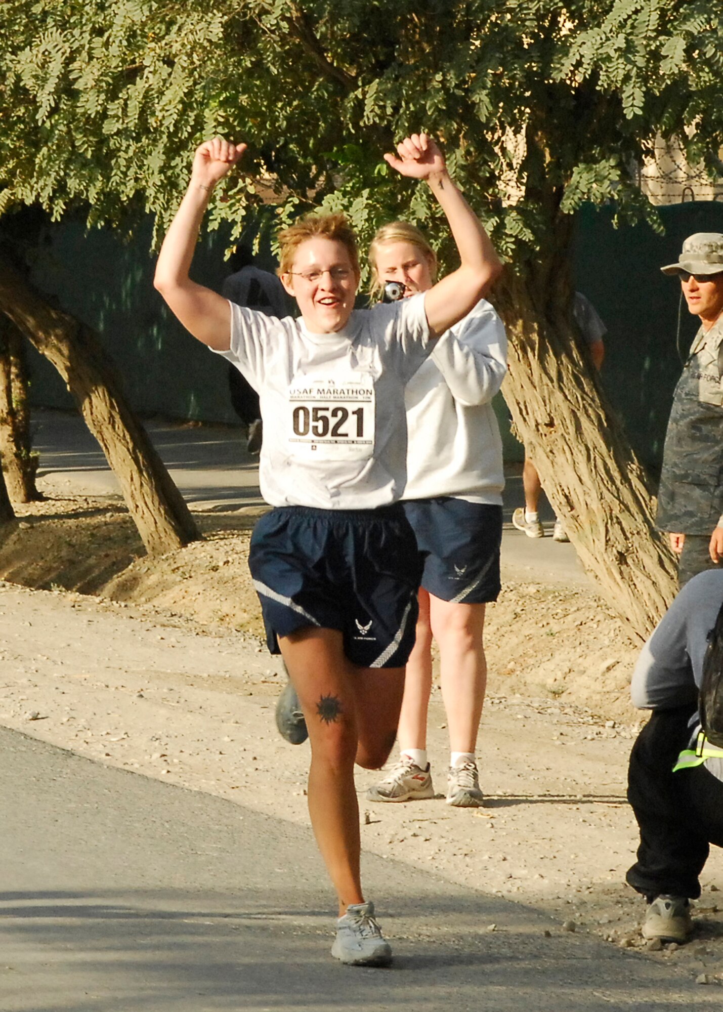 BAGRAM AIRFIELD, Afghanistan -- Staff Sgt. Majbritt Young, a Joint Task Force MED east/455th Expeditionary Medical Group pharmacy technician, raises her arms in triumph as she crosses the finish line of the Air Force Half Marathon here, Sept. 13, 2009.  The marathon organizers decided to hold it on the thirteenth of the month since it was the thirteenth annual AF Marathon.  Sergeant Young is deployed from RAF Lakenheath, England, and hails from Xenia, Ohio.   (U.S. Air Force photo/Senior Airman Felicia Juenke)