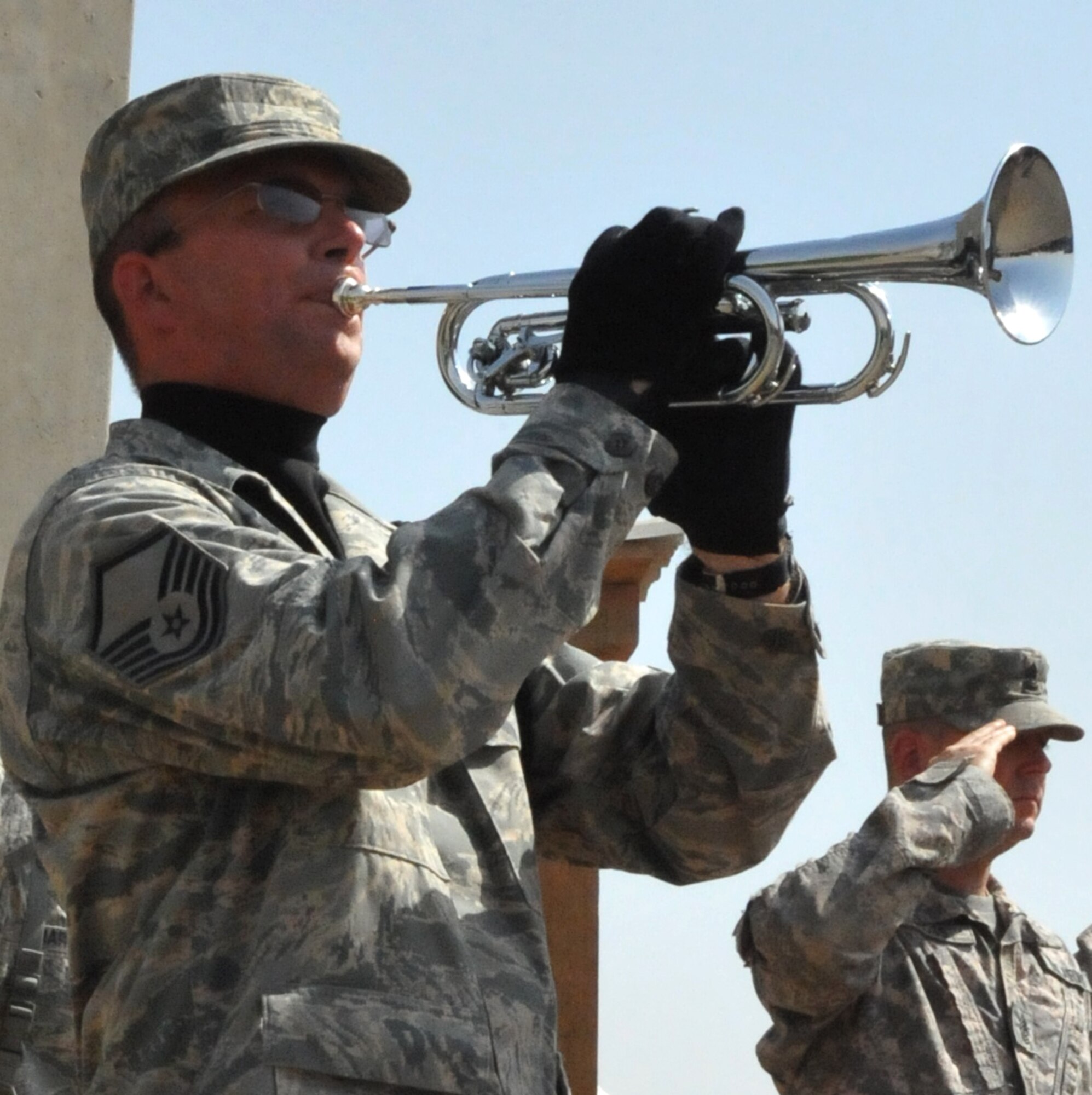 CAMP STRYKER, Iraq -- Master Sgt. Kent Nelson, Sather Air Base Honor Guard bugler, plays Taps during a memorial ceremony for 1st Lt. Joseph D. Helton Jr., 732d Expeditionary Security Forces Squadron, Detachment 2 flight commander.  Lieutenant Helton was deployed from the 6th Security Forces Squadron, MacDill Air Force Base, Fla. when he was killed by a roadside bomb that detonated close to his vehicle near Baghdad Sept. 8.  (U.S. Air Force photo/Staff Sgt. Misty D. Slater)