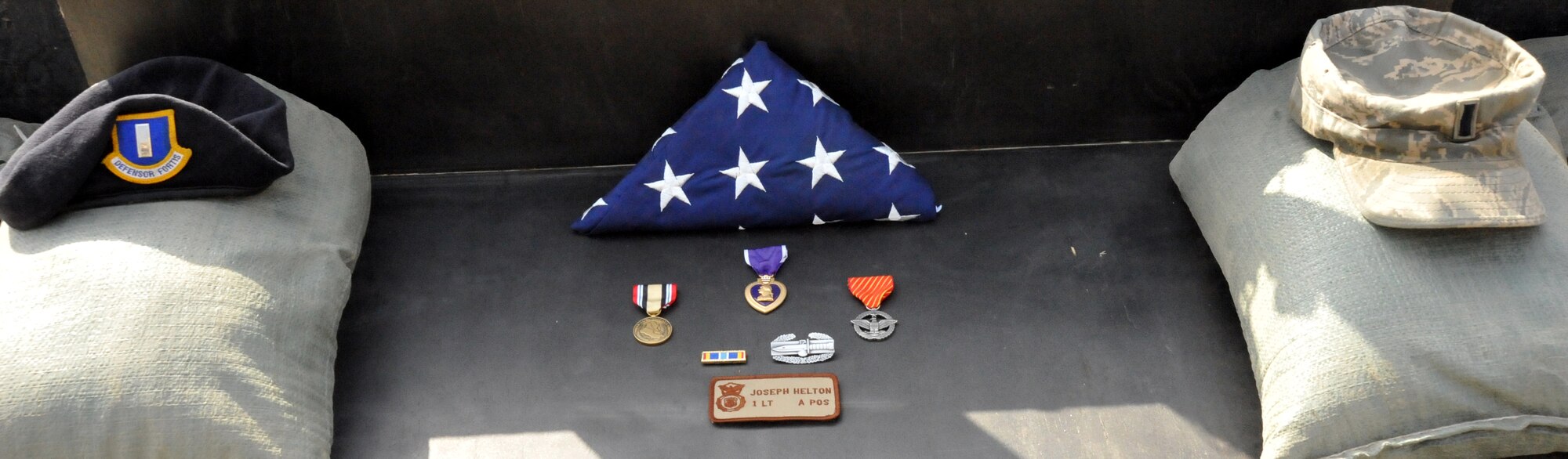 CAMP STRYKER, Iraq -- This folded American flag had been pulled out of 1st Lt. Joseph D. Helton Jr.'s backpack, which he had with him on his last mission.  "I don’t know how long he had been carrying that flag with him, but I would not be surprised if he carried it with him on all of his missions,” said Maj. Joe Engelbrecht, 732d Expeditionary Security Forces Squadron, Detachment 2 commander.  Lieutenant Helton perished when a roadside bomb detonated close to his vehicle near Baghdad Sept. 8. (U.S. Air Force photo/Staff Sgt. Misty D. Slater)